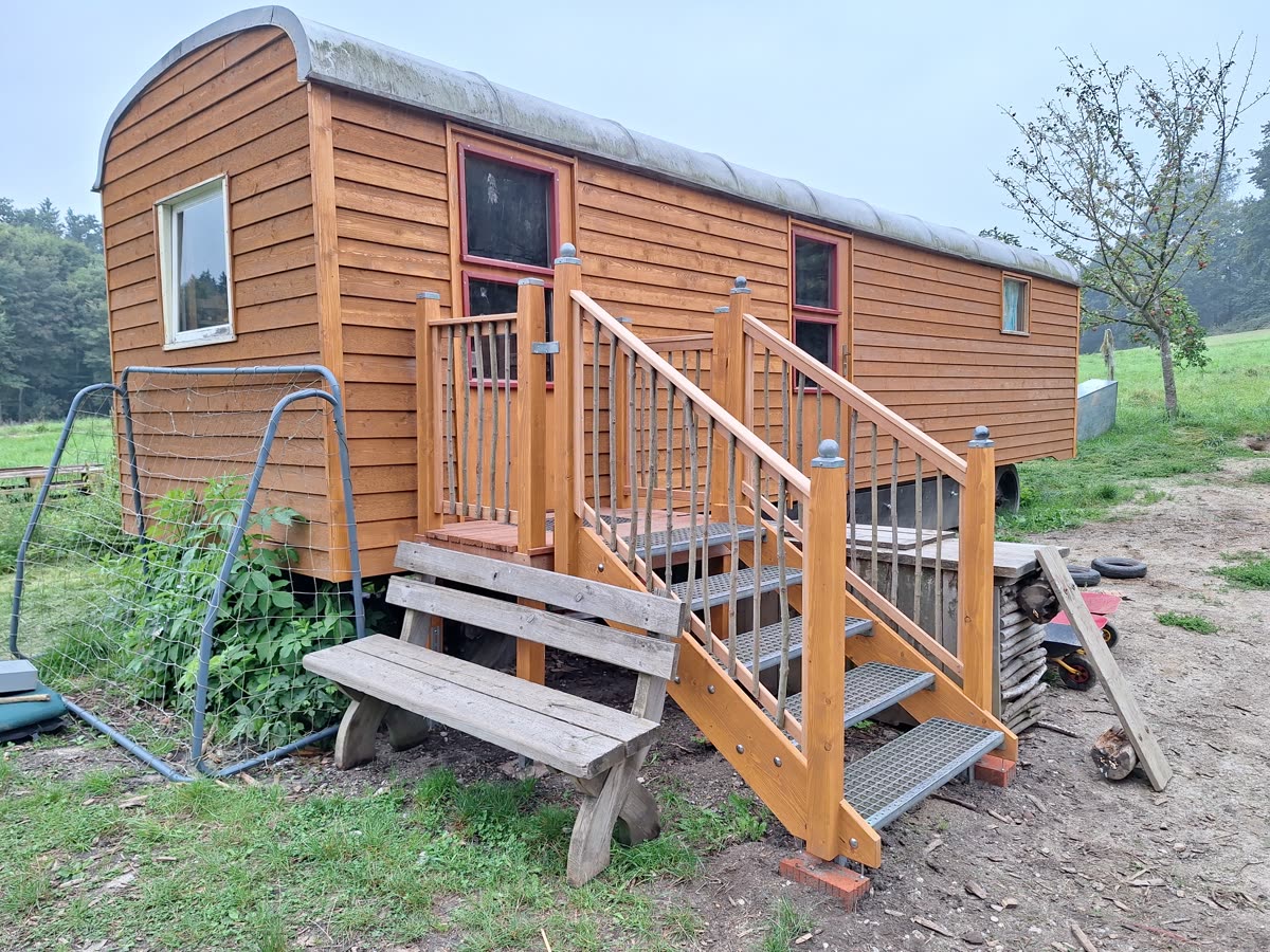 Der Bauwagen des Waldkindergartens mit Holztreppe am Waldrand